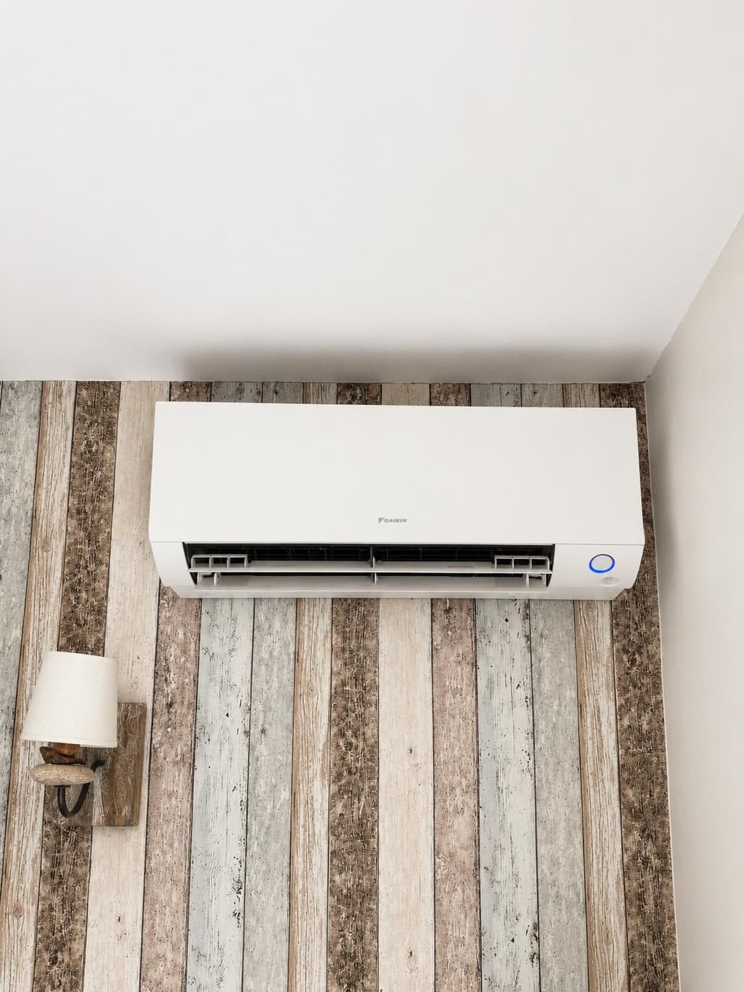 Unité murale de climatisation Daikin installée en hauteur dans une chambre