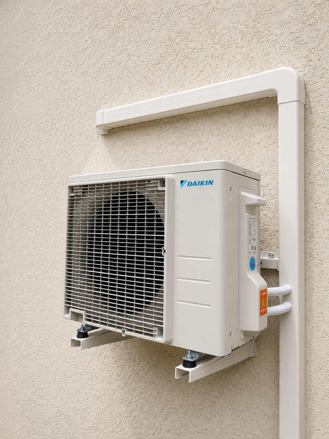 Groupe extérieur de climatisation Daikin avec goulotte en équerre et liaisons frigorifiques gainées
